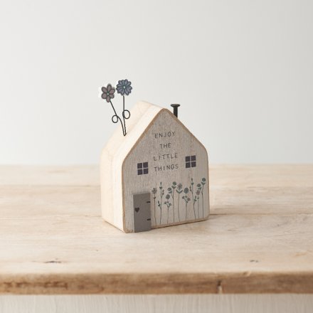Enjoy the little things. A charming wooden house with floral design including metal and wooden flowers
