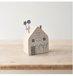 Enjoy the little things. A charming wooden house with floral design including metal and wooden flowers