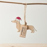 A wooden decoration with dachshund silhouette, red Santa hat and "Christmas is better with a dachshund" tag. 