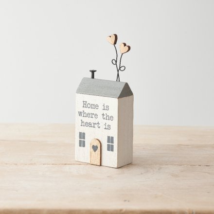 A sweet wooden house decoration with heart details and "home is where the heart is" text. 