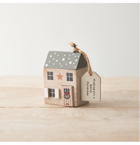 A charming wooden house ornament with traditional painted details and 3D wooden elements. 