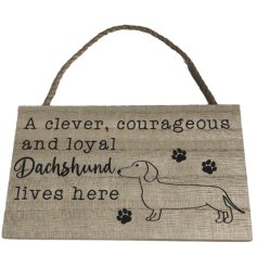 "A clever, courageous and loyal dachshund lives here" hanging wooden sign with paw print details.