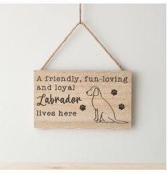 A hanging wooden sign with "a friendly, fun-loving & loyal Labrador lives here" text & illustration with paw prints.