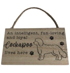 A hanging wooden sign with Cockapoo inspired illustration and message, with paw print details. 