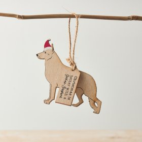 A charming hanging decoration of a German Shepherd wearing a Christmas hat, hung with some red string.