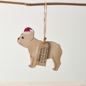 A simple yet cute hanging wooden decoration of a French Bulldog. The dog is wearing a festive hat and attached is a tag 