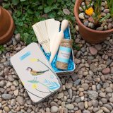 A gardening set in a storage tin decorated with a bright and beautiful bird design.