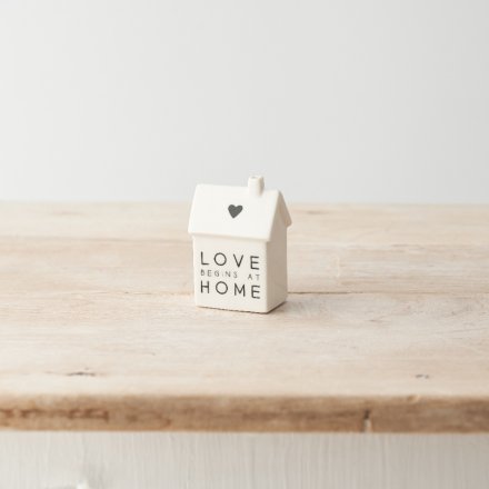 A charming porcelain house decoration with "love begins at home" message and cute heart motif. 