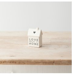 A sweet porcelain house decoration with heart motif, monochrome colour scheme and "love begins at home" message. 