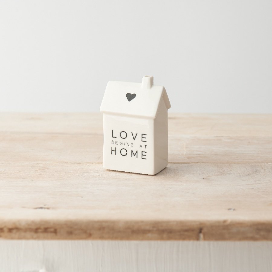 A stylish porcelain house decoration featuring cute heart motif and "love begins at home" message. 