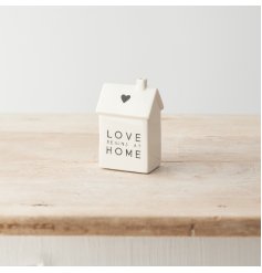 A charming porcelain house decoration with a monochrome colour scheme, "love begins at home" text and cute heart detail.