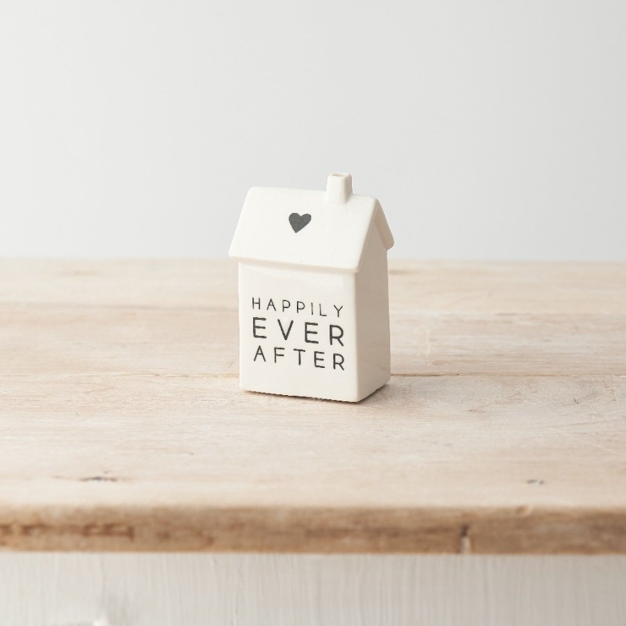 A cute porcelain house decoration with heart motif and "happily ever after" text.