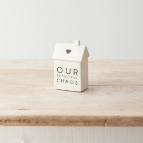 A stylish monochrome house decoration made from porcelain and decorated with "Our beautiful chaos" message. 