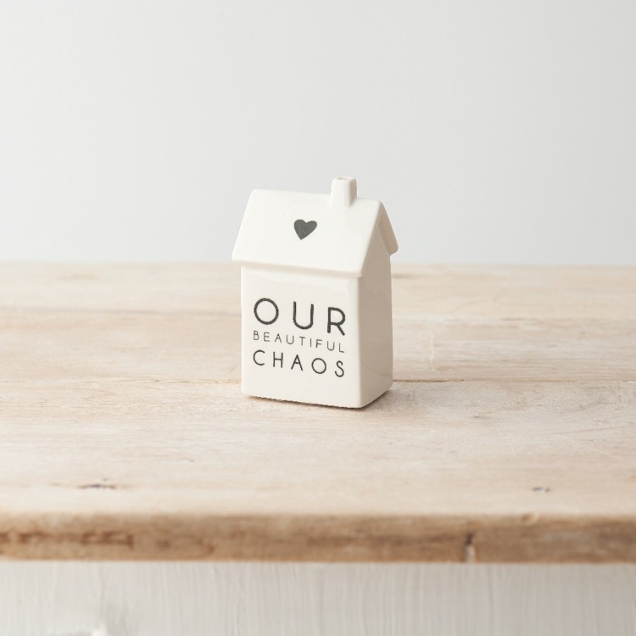 A stylish monochrome house decoration made from porcelain and decorated with "Our beautiful chaos" message. 