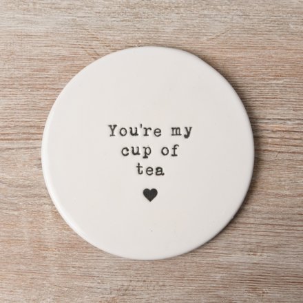 Keep surfaces safe whilst enjoying a cuppa with this charming porcelain coaster, complete with an embossed tea slogan. 