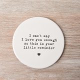 This round porcelain coaster is decorated with an embossed stamp style slogan.