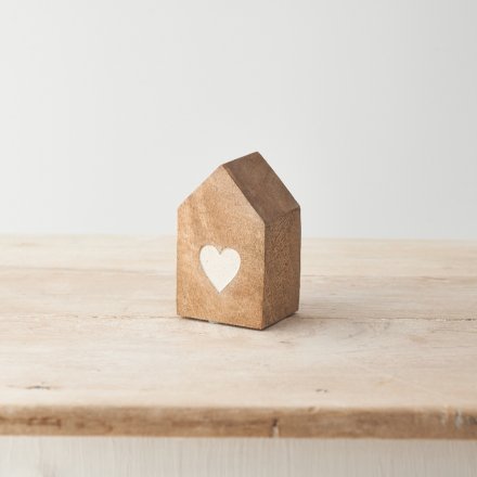 A chunky wooden house with an etched heart design. Crafted from mango wood with a natural finish.
