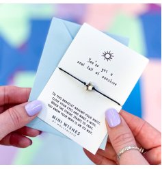 A corded bracelet with cute silver star charm on a "You've got a soul full of sunshine" card. 