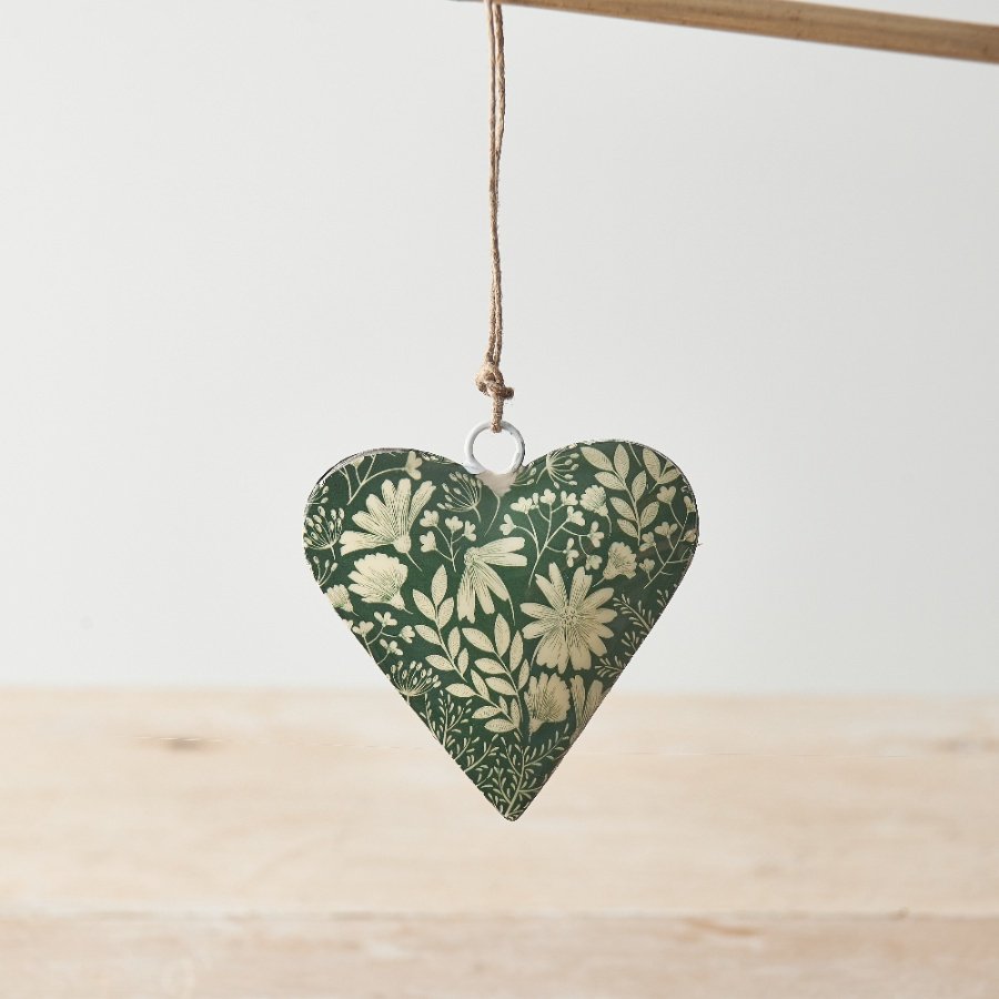 A beautiful botanical metal heart decoration in rich green and white colours. An earthy decoration with a rustic jute