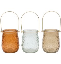 An assortment of 3 pretty candle holders, detailing a ribbed pattern on the glass and a golden handle 