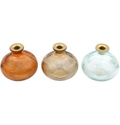 An assortment of 3 orange gold and blue candle holders in a ribbed design.