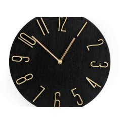 A black circular clock with contrasting gold arms and numbers.