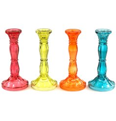 An assortment of 4 textured glass candlesticks. They are tall and slim with a wide base.