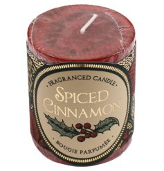 A small scented pillar candle with a mottled design, wrapped in clear cellophane with decorative card.