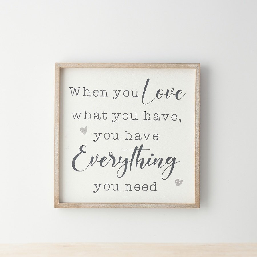 A cute wooden sign with a simple frame, displaying the words when you love what you have, you have everything you need" 