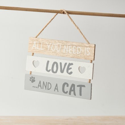 A decorative wooden hanging plaque featuring scripted text a heart cut out details and a paw print