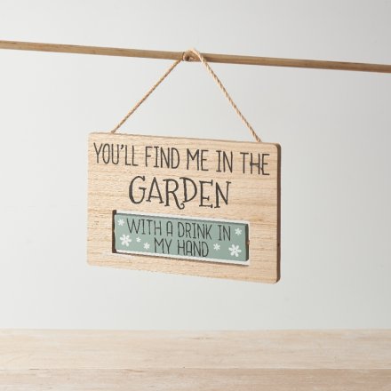 An assortment of 2 wooden signs with quirky writing hung by twine.