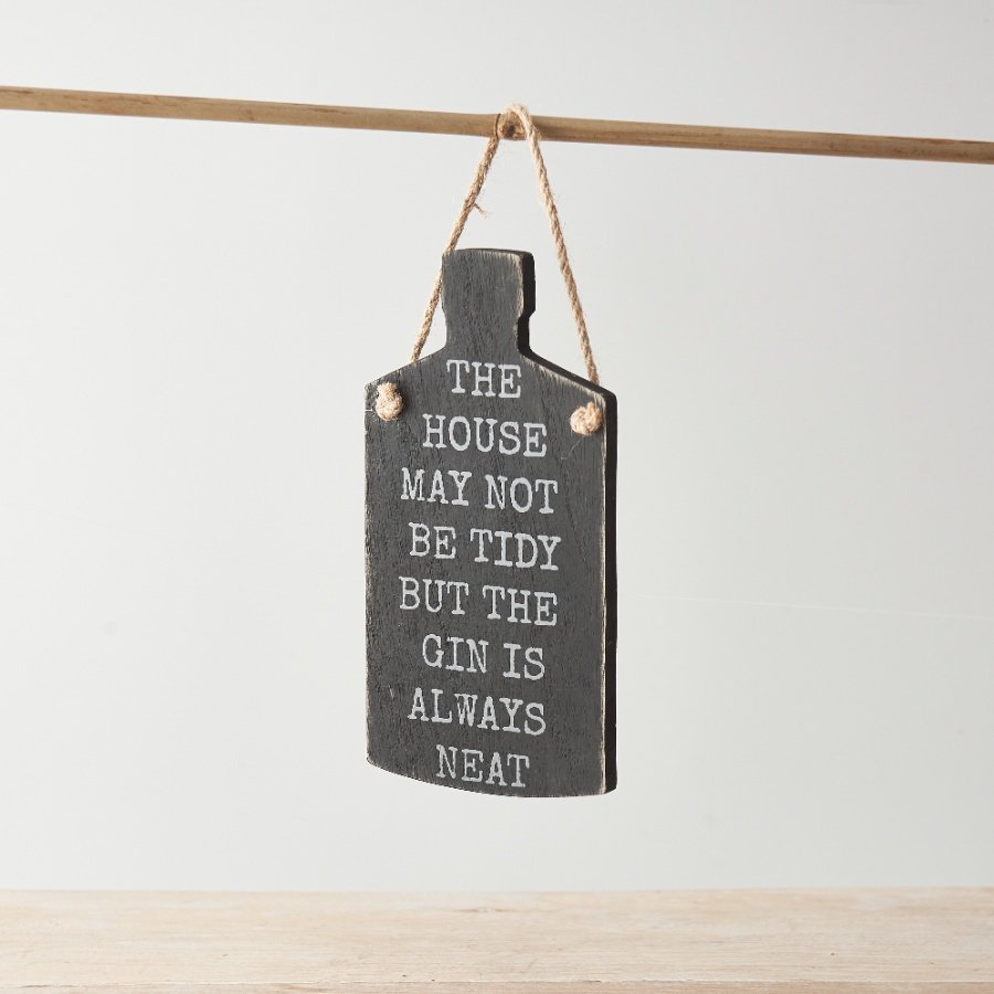 A black wooden hanging sign with wording 'The house may not be tidy, but the gin is always neat'