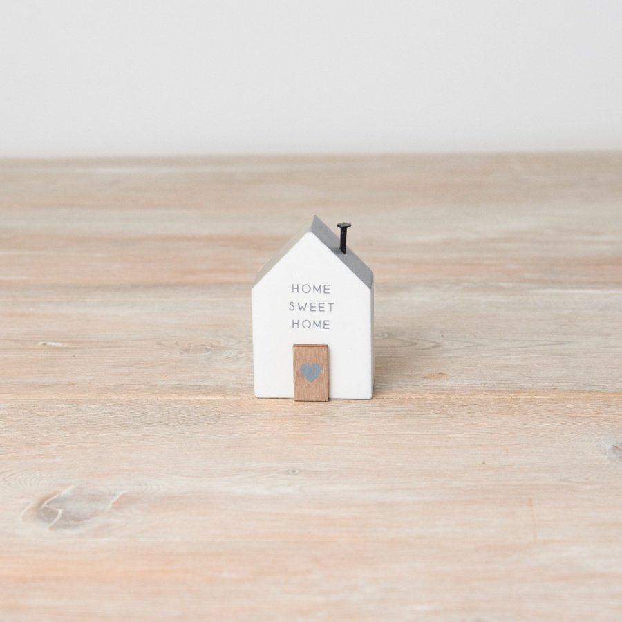 This adorable little house ornament is perfect for any shelf or mantel! It details 'home sweet home' text, a nail chimne