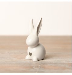 A simplistic white rabbit decoration featuring a dainty heart decal printed on its chest.