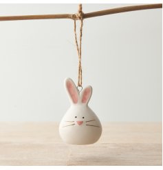 A charming bunny shaped decoration with pink pastel details and a rustic jute string hanger. 