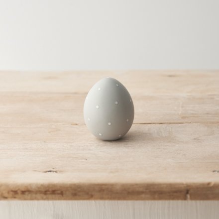 Adorn the home with this stylish and elegant egg ornament in a classic grey hue. Decorated with white polka dots. 