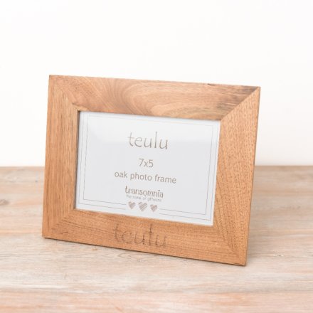 A simple oak photo frame engraved with 'Teulu', Family in Welsh.