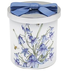 A candle from the Bee - tanicals range, featuring a Bluebell design printed around the candle, complete with a chrome 