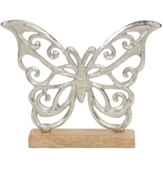 A silver butterfly stood on a rustic wooden base.