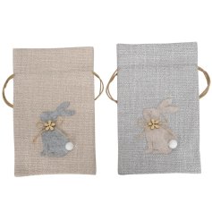 2 assorted small trinket pouches with a material bunny and a dainty pom pom and wooden flower decal.