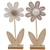A sweet flower decoration mounted on a wooden base with a pom pom centre.