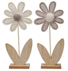 2 assorted pom pom flower ornaments with a wooden base.