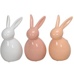 An assortment of 3 bunny statues in pastel pink and creams. 
