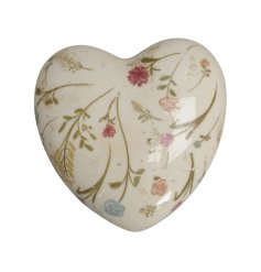 A vintage style ornament in the shape of a heart, detailing mini flower decals and finished with a glaze.