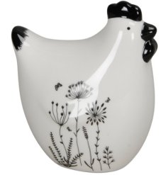 A simple chicken ornament in white with intricate black flowers painted around the bottom. 