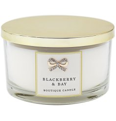 A luxury candle with a Blackberry and Bay fragrance. It details a gold jewel bow and sealed with a golden lid.