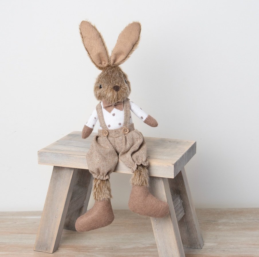 An adorable faux fur bunny decoration with flexible ears and a charming rustic outfit. 