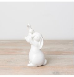 A charming bunny ornament featuring a small and large bunny embracing and kissing. 