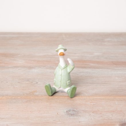 A charming sitting duck figure in sage green wellies, jacket and hat. 