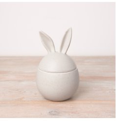 A stylish egg shaped storage container in an off white colour with a speckled finish. 